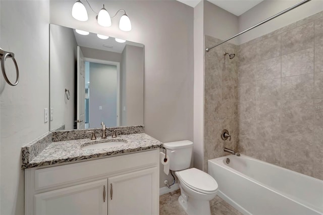 full bathroom with tile floors, tiled shower / bath combo, vanity, and toilet