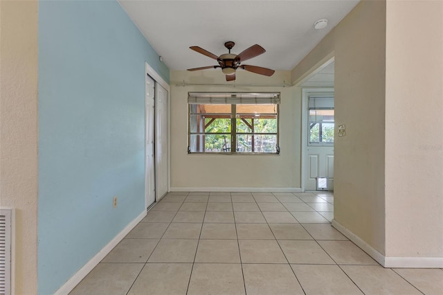 empty room with ceiling fan and light tile patterned flooring