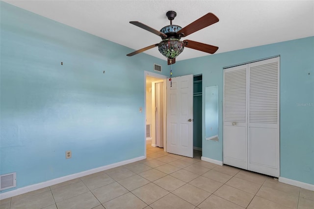 unfurnished bedroom featuring ceiling fan, a closet, and light tile patterned floors