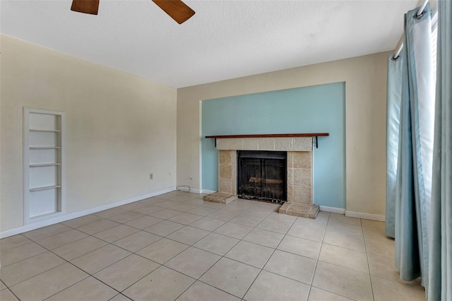 unfurnished living room featuring a textured ceiling, built in shelves, light tile patterned floors, and a fireplace