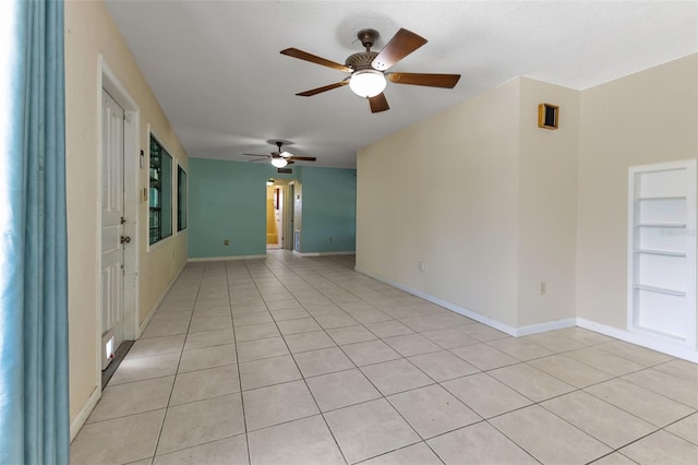 tiled spare room with ceiling fan