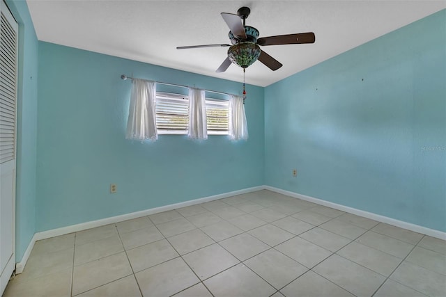 tiled spare room with ceiling fan