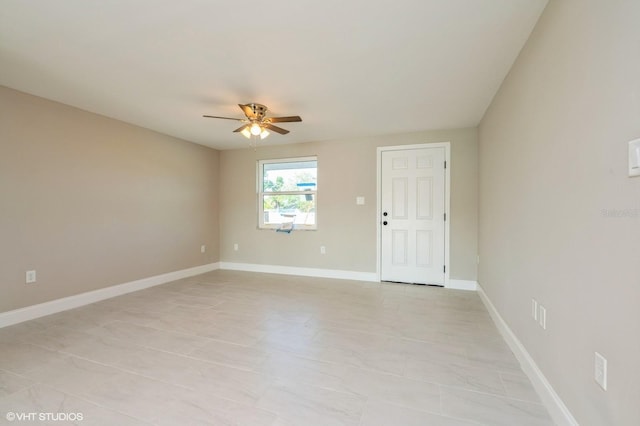 tiled spare room with ceiling fan