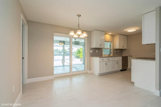 kitchen with light stone counters, white cabinetry, and light tile floors