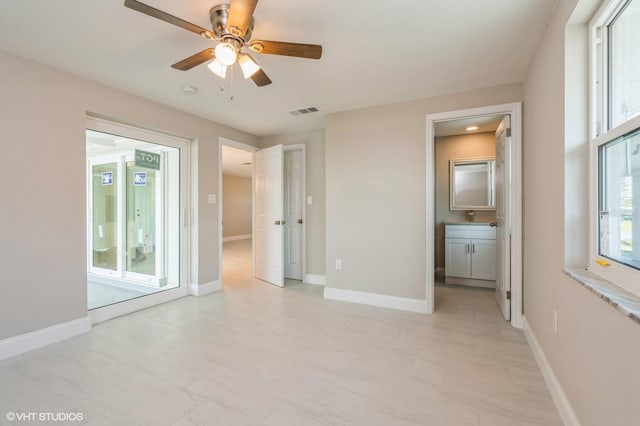 interior space with ensuite bathroom, multiple windows, and light tile floors