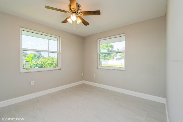 tiled empty room featuring ceiling fan