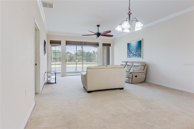 carpeted living room featuring ceiling fan with notable chandelier and crown molding