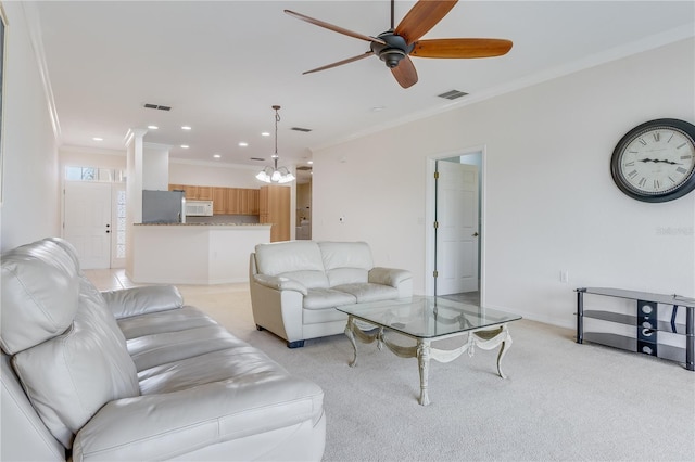 living room with ornamental molding, ceiling fan, and light colored carpet