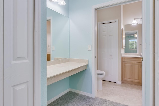 bathroom with toilet, vanity, ceiling fan, and tile floors