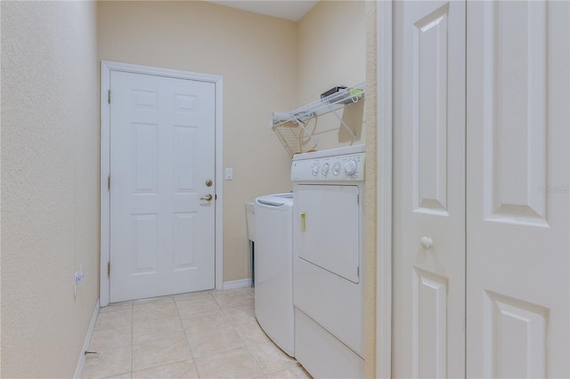 clothes washing area with light tile floors and washing machine and dryer