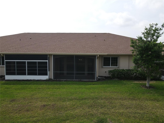 back of property with a sunroom and a lawn