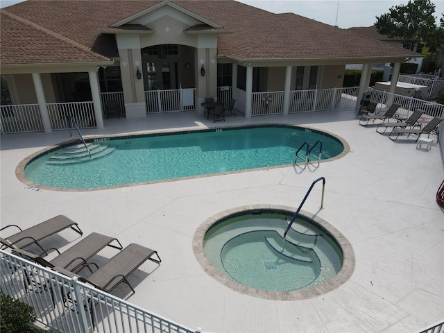 view of swimming pool with a community hot tub and a patio area