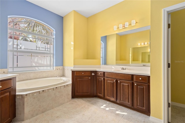 bathroom featuring tile flooring, tiled tub, and vanity