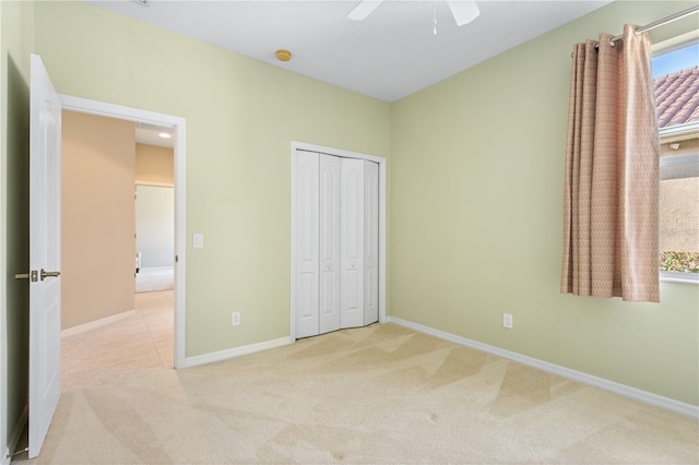 unfurnished bedroom with carpet, a closet, and ceiling fan