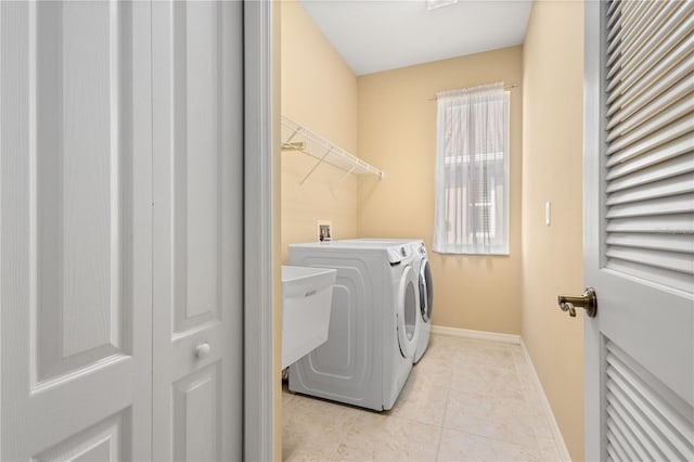 washroom with washer hookup, light tile flooring, and washing machine and dryer