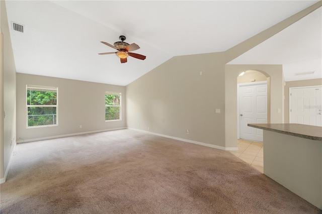 carpeted spare room featuring ceiling fan and lofted ceiling