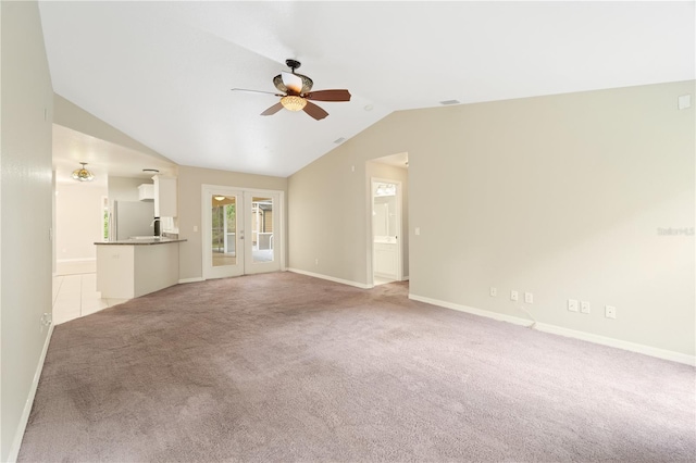 unfurnished living room featuring light colored carpet, ceiling fan, french doors, and lofted ceiling