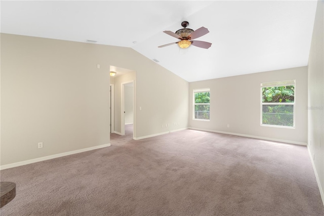 empty room with ceiling fan, vaulted ceiling, and carpet flooring