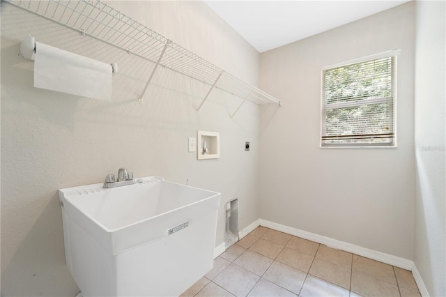 washroom with electric dryer hookup, sink, washer hookup, and light tile floors