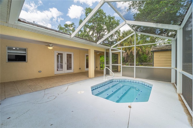 view of swimming pool featuring glass enclosure, a patio area, ceiling fan, and french doors