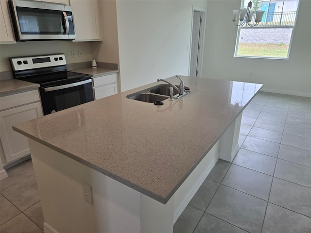 kitchen featuring sink, white cabinets, a center island with sink, and appliances with stainless steel finishes