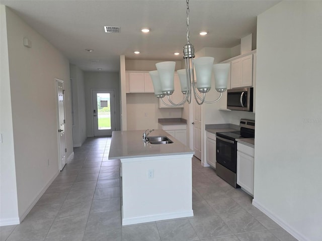 kitchen with stainless steel appliances, sink, white cabinetry, and an island with sink