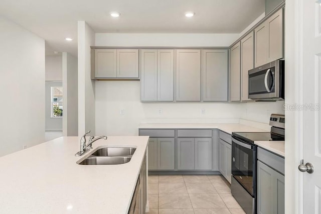 kitchen featuring gray cabinetry, sink, range with electric cooktop, and light tile flooring