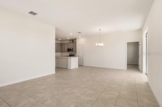 unfurnished living room with a chandelier and light tile floors