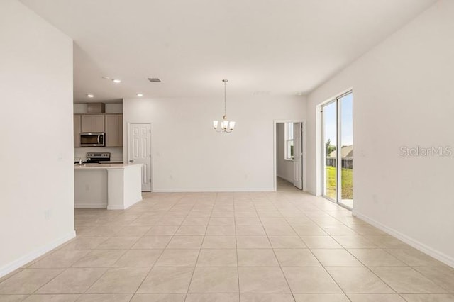 unfurnished living room with a notable chandelier, a wealth of natural light, and light tile flooring