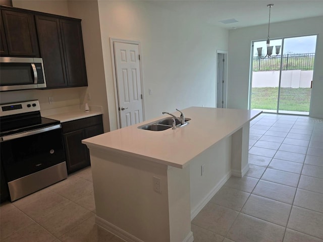 kitchen with sink, light tile floors, a center island with sink, and appliances with stainless steel finishes