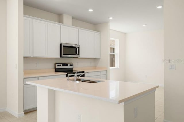 kitchen featuring stainless steel appliances, a center island with sink, and white cabinets