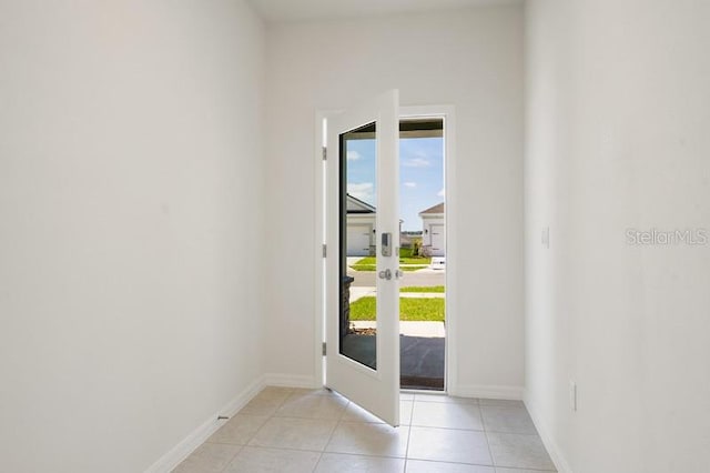 entryway with a wealth of natural light, french doors, and light tile floors