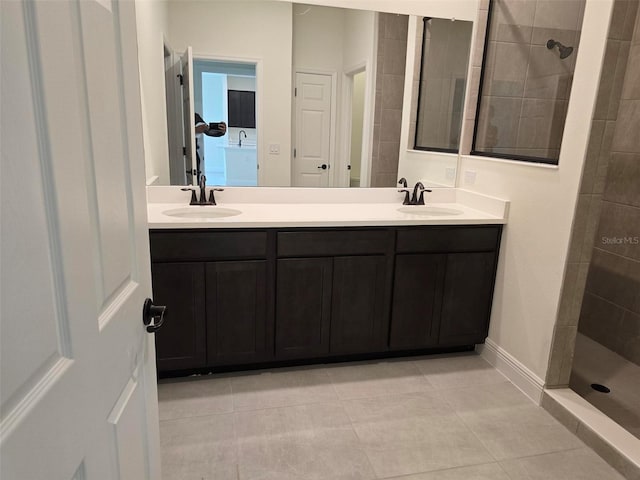 bathroom with tile floors, a tile shower, and double vanity