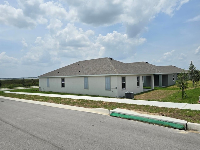 single story home featuring central AC and a front lawn