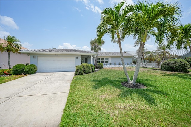 single story home featuring a garage and a front lawn