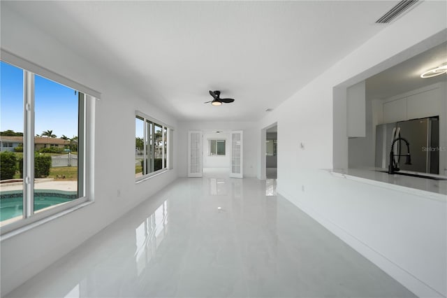 unfurnished room with tile flooring, ceiling fan, and sink