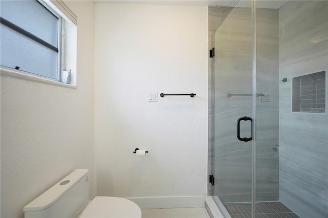 bathroom featuring an enclosed shower and toilet