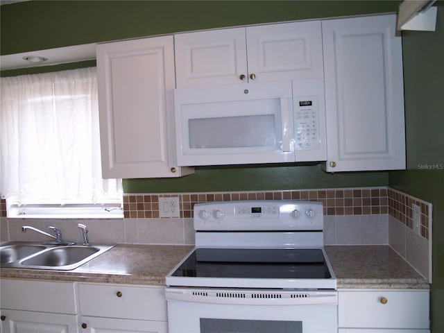 kitchen featuring sink, tasteful backsplash, white appliances, and white cabinetry