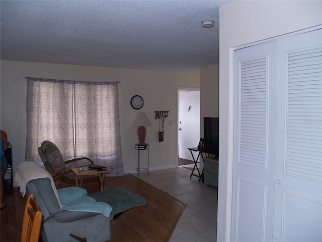 tiled living room featuring a textured ceiling