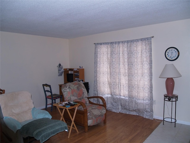 sitting room with tile floors and a textured ceiling