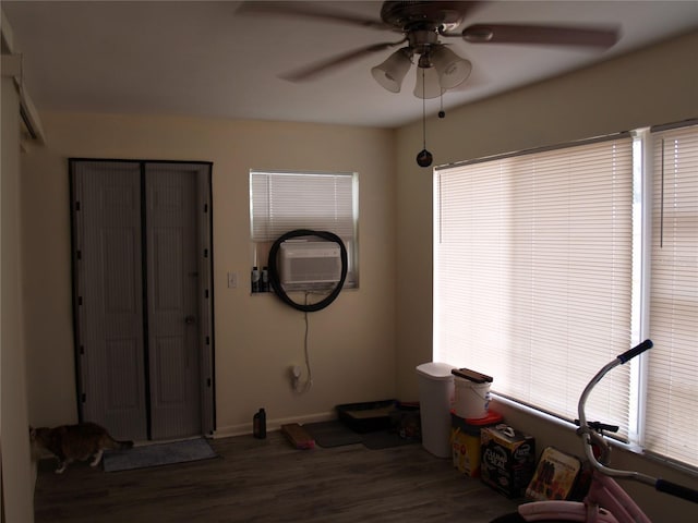 misc room featuring ceiling fan, a wall mounted AC, and wood-type flooring