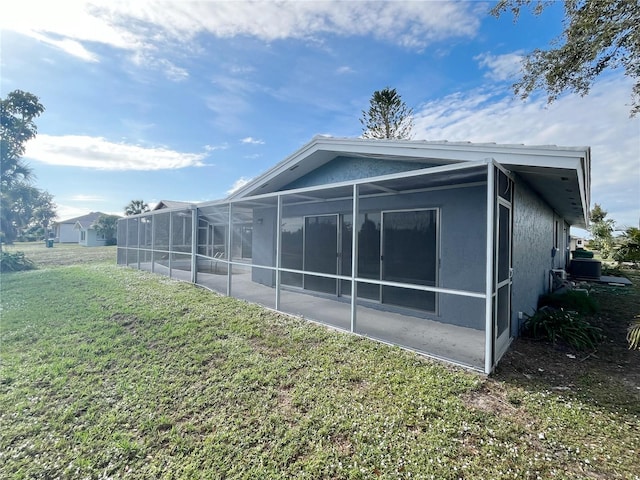 back of house with a lanai and a yard