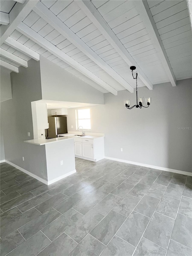 unfurnished living room with tile flooring, vaulted ceiling with beams, and an inviting chandelier