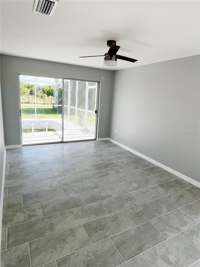 empty room featuring ceiling fan and tile floors