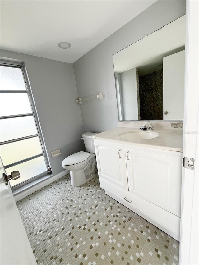 bathroom with tile flooring, vanity, and toilet