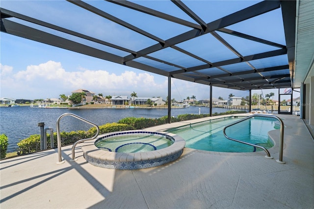 view of pool with an in ground hot tub, a patio area, and a water view