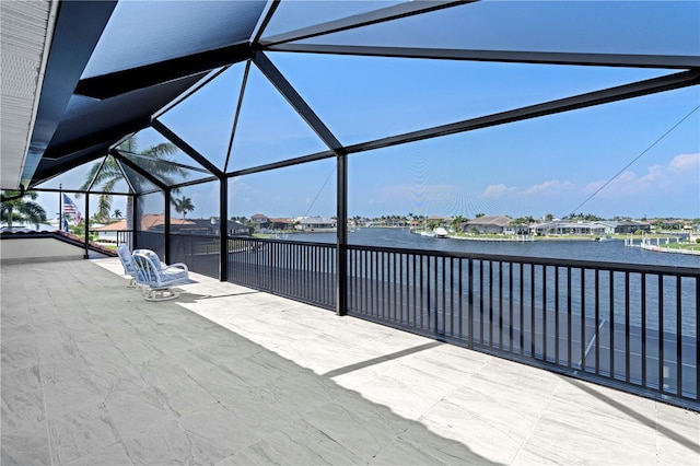 view of patio / terrace featuring glass enclosure and a water view