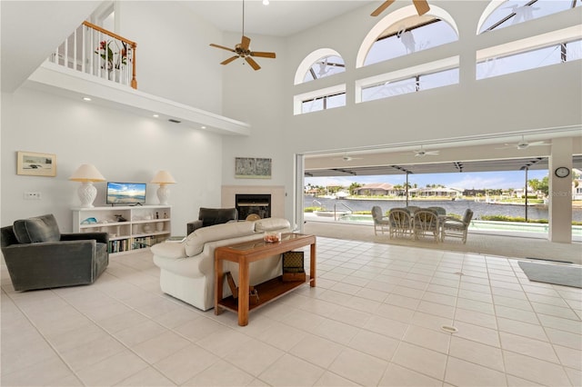 tiled living room with a high ceiling and ceiling fan