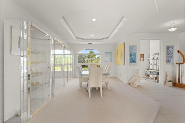 dining space featuring a raised ceiling and light tile patterned floors