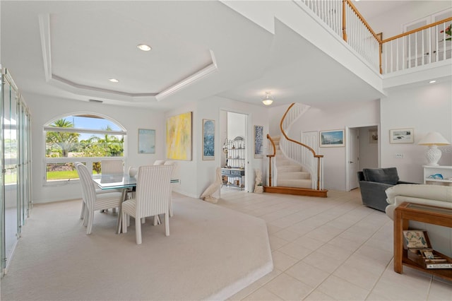 dining space with light tile patterned floors and a raised ceiling